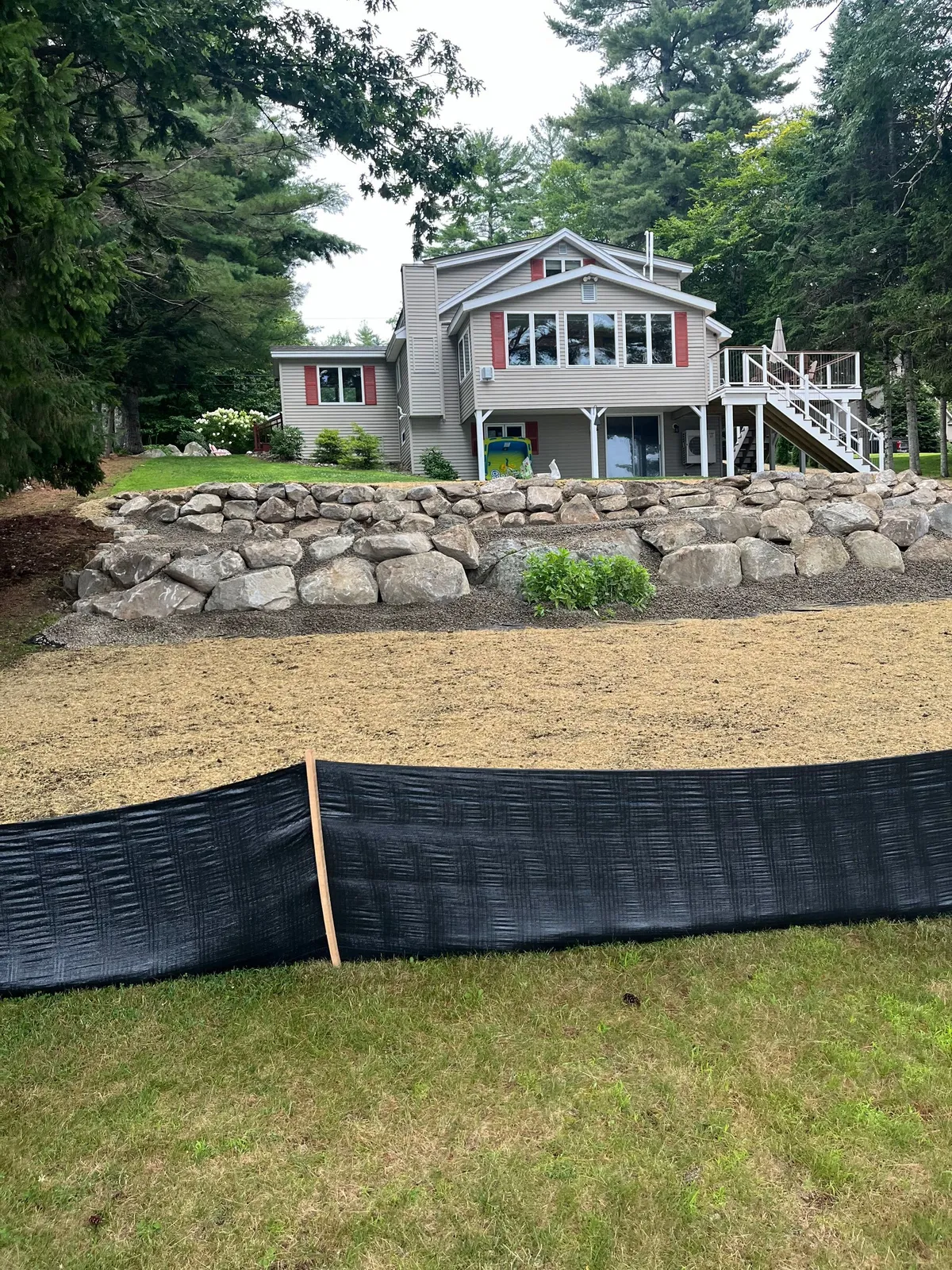 Rock wall and grading work along a slope.